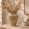 Beige Keramikvase mit Relief und Trockenblumen auf einer hellen Konsole